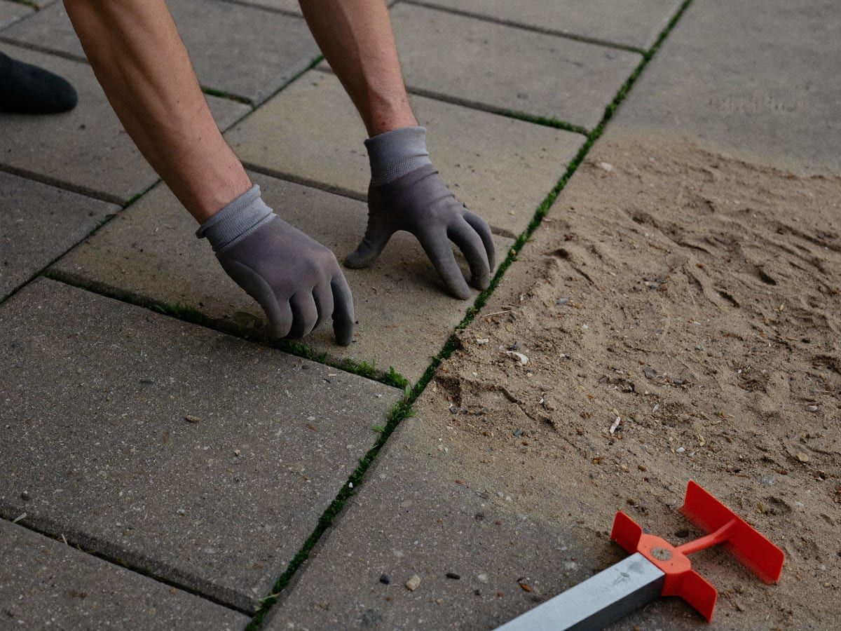 Paver setting a block by hand